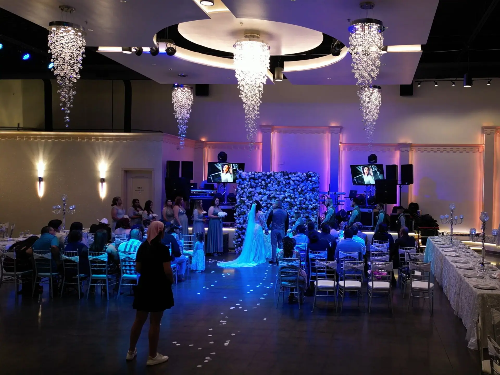 Elegant ballroom setup with premium decorations included in the Decor package from DFW Celebrations. Perfect for private events, weddings, and special occasions in our luxurious event venue and banquet hall. Wedding Reception, Wedding Venue, Full Bar, Amenities, Bride & Groom, Green and Gold color scheme, Tall centerpieces, white and cream flowers